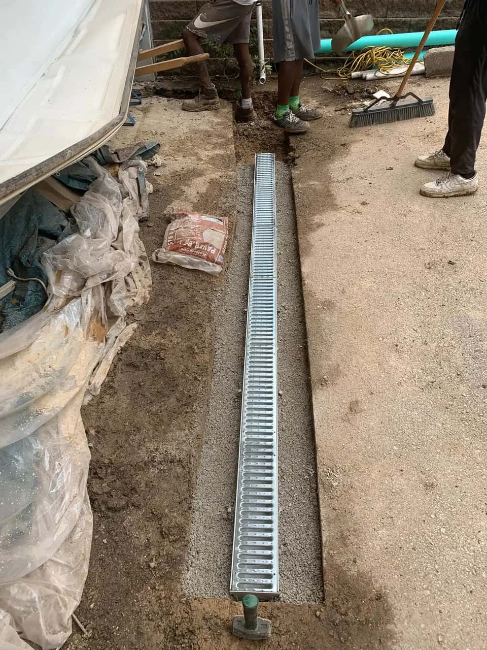 Channel drain installed in a driveway-edge trench