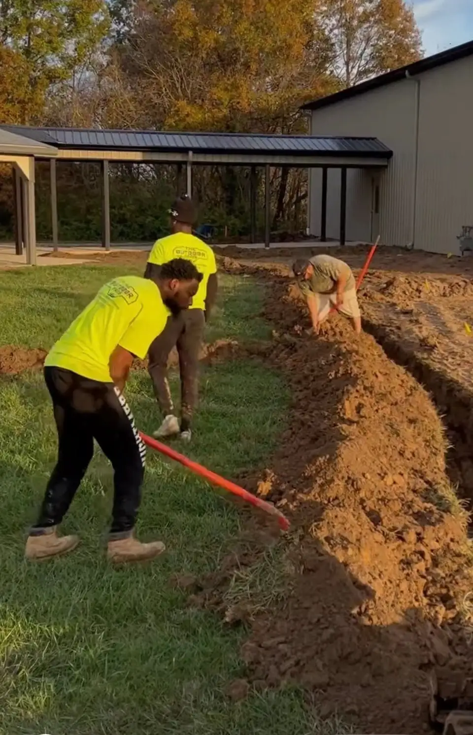 Crew trenching a yard for a drainage system