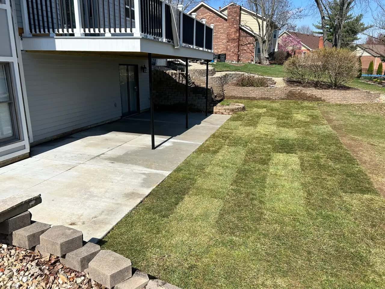 Newly graded and sodded yard beside a patio