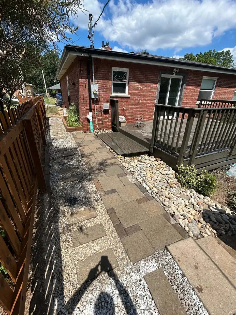 Brick home side yard with paver walkway and river rock border