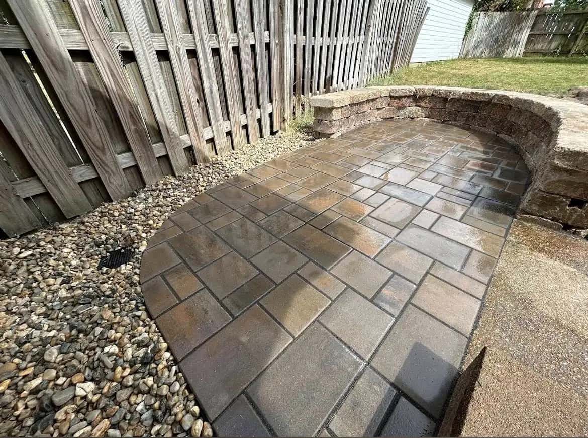 Paver walkway with stone retaining wall and river rock
