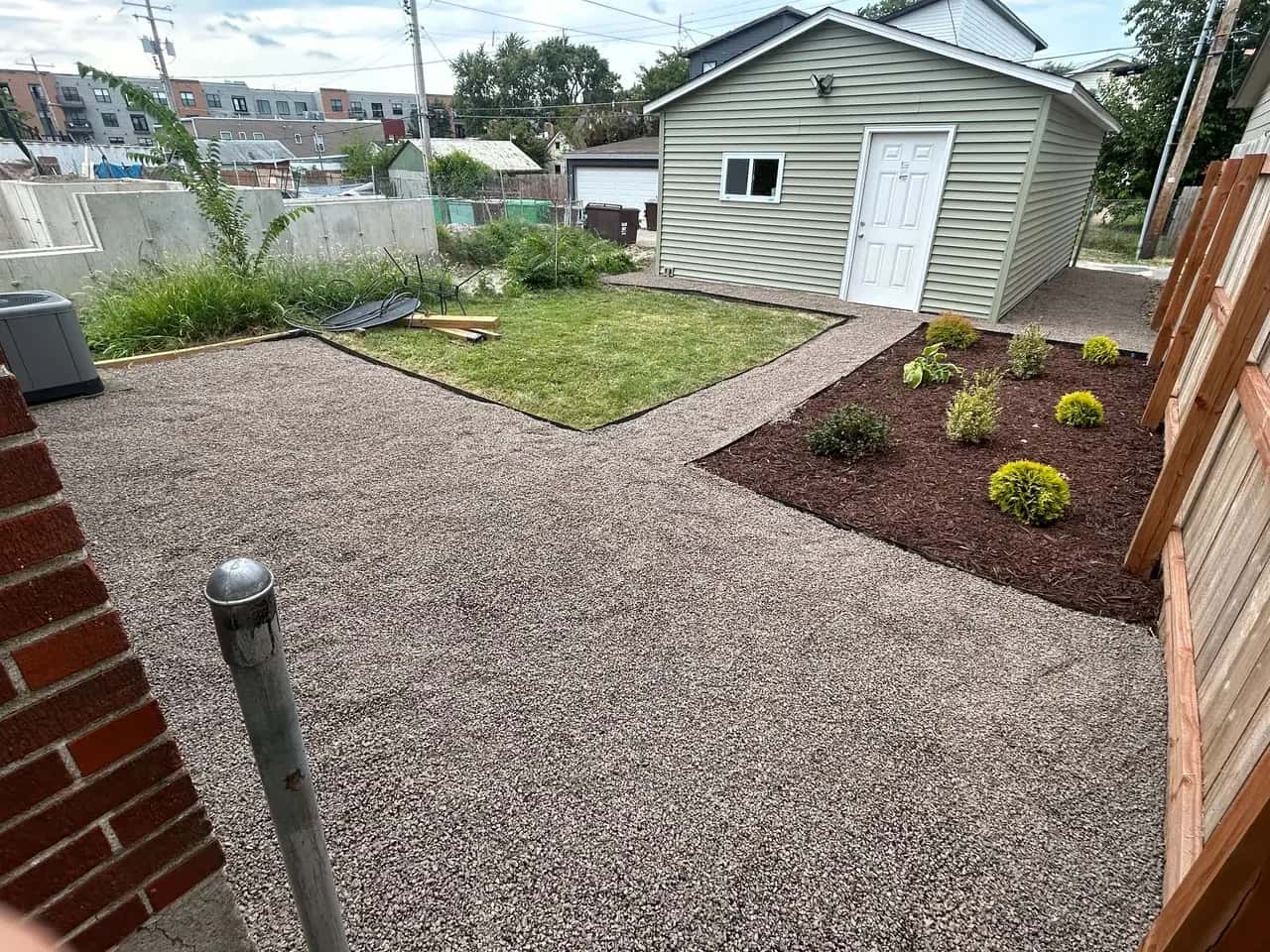 Backyard gravel area and new shrub bed beside a shed