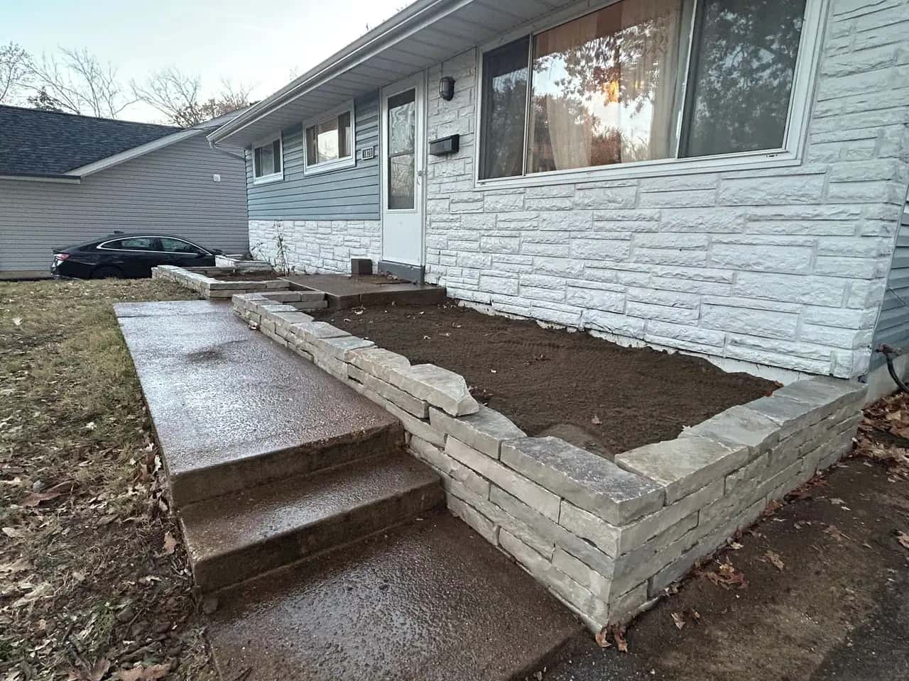 Stone retaining wall and steps at a front yard planting bed