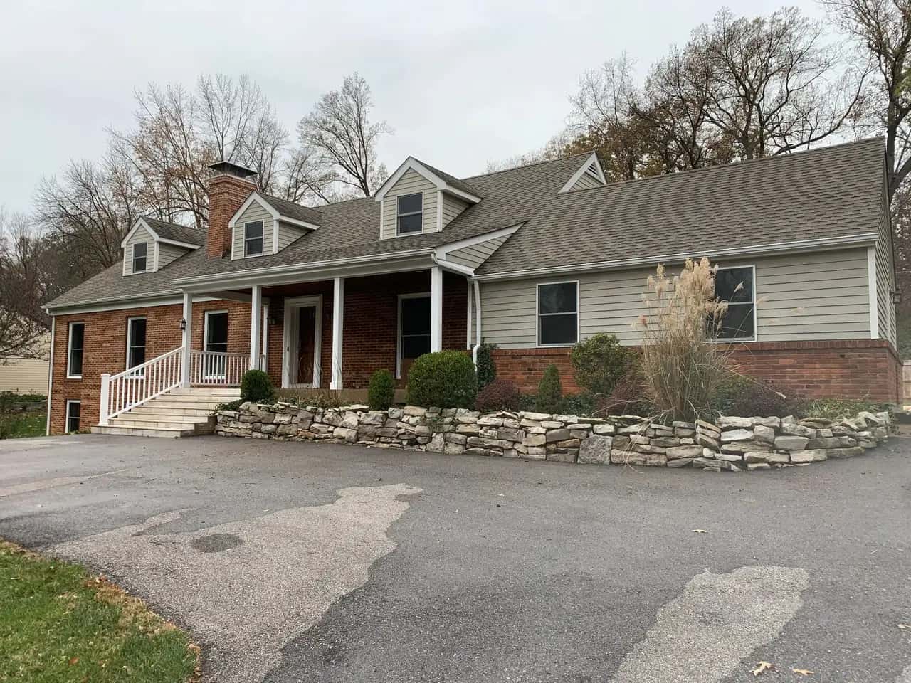 Ranch home with a natural stone retaining wall along the driveway