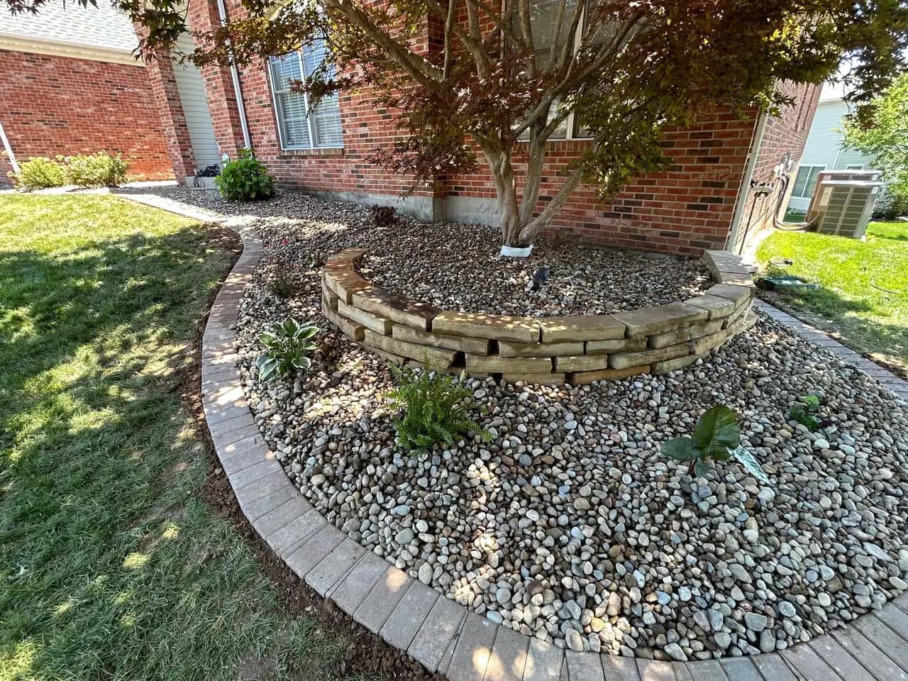 Tiered stone planter ring with river rock and edging